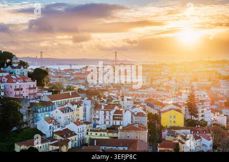 Belle vue sur Lisbonne au coucher du soleil depuis Miradouro da Senhora do Monte, mettant en valeur le paysage urbain et les ponts emblématiques. Banque D'Images
