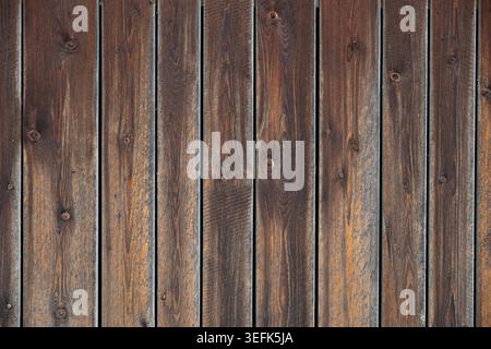 Planches en bois brun foncé altérées avec grain visible, nœuds et espaces étroits, fond de texture de bois vertical rustique pour une utilisation de conception. Banque D'Images