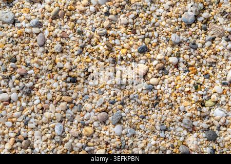 Gros plan horizontal de galets de mer organiques lisses et de texture de sable grossier. Tons naturels terreux avec beaucoup d'espace de copie. Vue de dessus haute résolution Banque D'Images