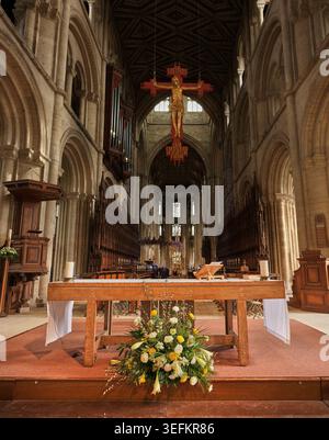 Bouquet de fleurs devant un autel simple dans la nef de la cathédrale chrétienne de Peterborough, Angleterre. Banque D'Images