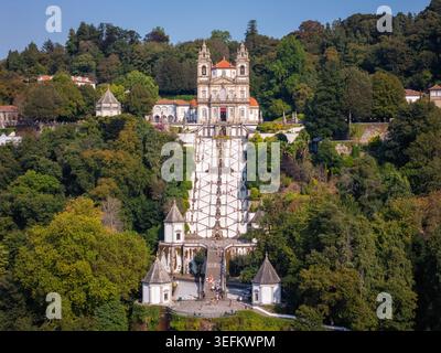 Cette photo aérienne montre le Bom Jesus do Monte à Braga, au Portugal. Le sanctuaire comporte un grand escalier et une église visibles parmi les arbres. C'est une impor Banque D'Images