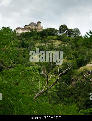 Ruine du château médiéval au sommet d'une colline s'élève au-dessus de la forêt luxuriante colline vallée Vinschgau ruine du château médiéval avec tour ronde s'élève au-dessus de la forêt luxuriante vert avant Banque D'Images