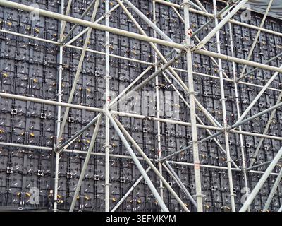 Gros plan du cadre d'échafaudage métallique supportant un grand panneau de mur vidéo LED, montrant le câblage complexe et la construction modulaire pour les événements ou Banque D'Images