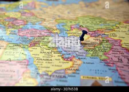 Épingle bleue mettant en évidence l'Iran sur papier carte du monde Macro gros plans avec flou doux Banque D'Images