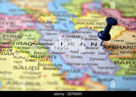 Blue Map pin mettant en évidence l'Iran sur Vintage Worlds Atlas Macro Photography Banque D'Images