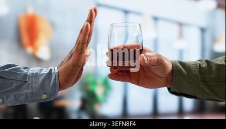 Jeune homme afro-américain en Formalwear levant la main pour refuser de boire. Banque D'Images