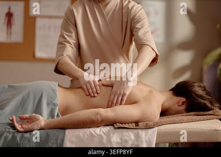 Homme adulte recevant un massage du dos pour une thérapie de bien-être Banque D'Images