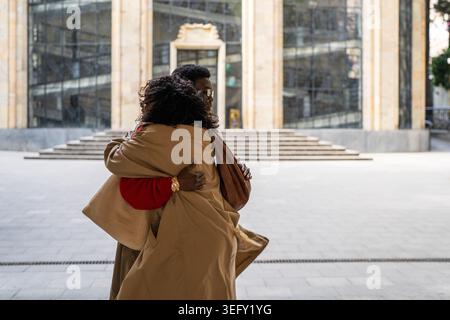 Amies afro-américaines à la mode se réunissant dans la rue de la ville et s'embrassant. Banque D'Images
