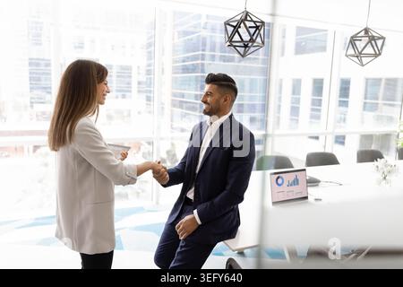 Femme d'affaires et homme d'affaires serrant la main dans la salle de conférence moderne Banque D'Images