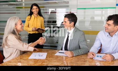 Femme d'affaires serrant la main avec homme d'affaires au bureau Banque D'Images