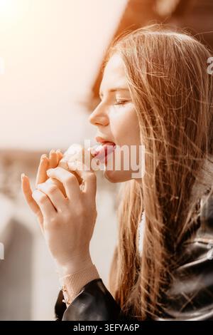 Femme crème glacée léchant jeune femme léchant cône de crème glacée fraise dans une tasse de gaufre sur une journée ensoleillée lumineuse à l'extérieur Banque D'Images