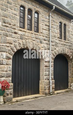 bâtiment rustique en pierre avec portes de garage cintrées, vue d'angle latérale avec espace de copie, concept historique d'architecture européenne Banque D'Images