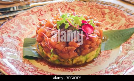 Tartare de saumon avec avocat et légumes verts sur une assiette Banque D'Images