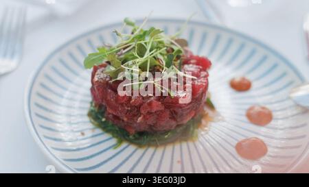 Tartare de thon avec algues et légumes verts sur une assiette Banque D'Images