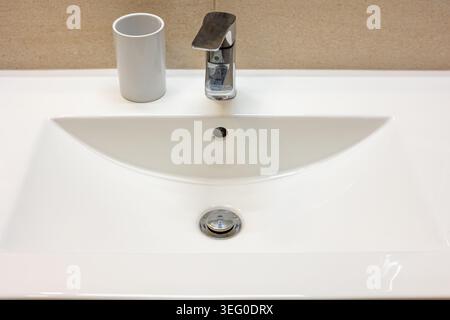 Vue de face de détail d'un lavabo de salle de bain avec un robinet chromé. Horizontalement. Banque D'Images