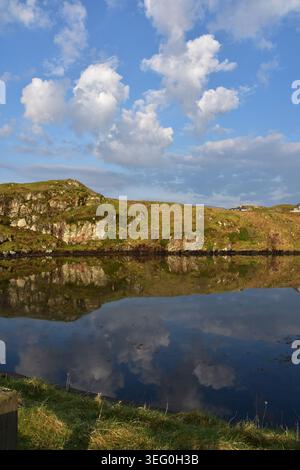 Nuage et paysage rocheux reflétés dans la surface des lochs en Écosse. Banque D'Images