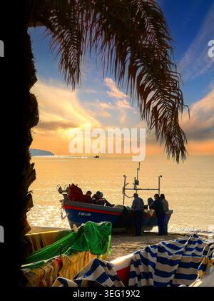 Pêcheur réparant des filets sur la plage de Playa de Burriana, Nerja, Andalousie, Espagne Banque D'Images