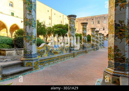 NAPLES, ITALIE. Le célèbre cloître de Santa Chiara avec des colonnes en céramique ornées et des bancs dans le centre historique de Naples Banque D'Images