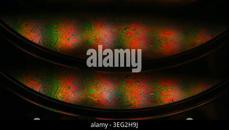Arc-en-ciel essence. Mélange de peinture. Flou vert orange violet coloré texture huile ronde goutte chimique liquide déversement sur fond d'art noir abstrait. Banque D'Images