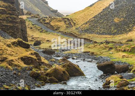 Magnifique paysage islandais printanier avec des montagnes, des roches volcaniques couvertes de mousse et une rivière près de Kvernufoss, une cascade sur la rivière Skoga Banque D'Images