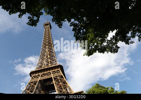 Tour Eiffel vue à travers les arbres du dessous de la tour du côté champ de mars à Paris, France. Banque D'Images