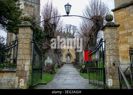 Vue d'entrée de l'église St James dans les Cotswolds. Cette « église de laine » historique est construite en pierre Cotswold de couleur miel Banque D'Images