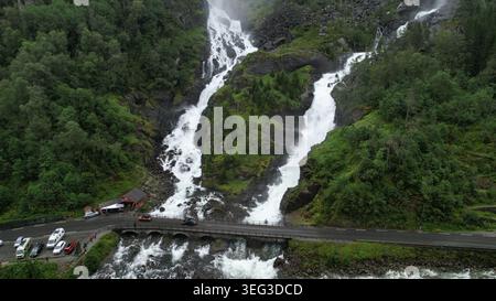 Vue aérienne spectaculaire de la célèbre cascade de Låtefossen en Norvège, avec deux cascades coulant à côté d'un pont de pierre historique, entouré d'une végétation luxuriante Banque D'Images