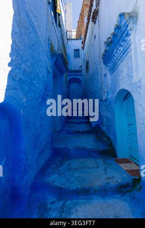 Étroite ruelle bleue avec des escaliers en pierre dans la médina historique de Chefchaouen, Maroc. Architecture marocaine traditionnelle scène de rue dans la célèbre ville bleue. Banque D'Images