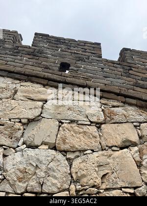 La Grande Muraille de Mutianyu serpente à travers les montagnes boisées près de Pékin, présentant des tours de guet historiques, une architecture en pierre ancienne et des paysages pittoresques. Banque D'Images