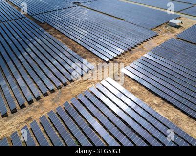 Vue surélevée d'une ferme solaire photovoltaïque à grande échelle démontrant une infrastructure d'énergie renouvelable et une production d'énergie durable. Banque D'Images