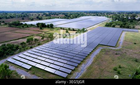 Vue surélevée d'une centrale photovoltaïque à grande échelle dans des champs agricoles présentant une infrastructure industrielle d'énergie renouvelable. Banque D'Images