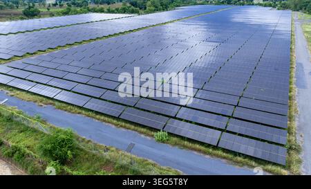 Vue surélevée d'une ferme solaire commerciale à grande échelle montrant des rangées organisées de modules photovoltaïques pour la production d'énergie renouvelable. Banque D'Images