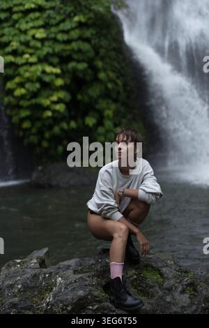 Jeune femme reposant sur le rocher à la cascade de Banyumala Twin, Bali Banque D'Images