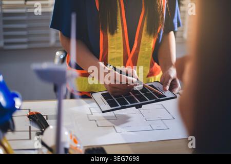 Deux techniciens inspectent les racks de serveurs dans le centre de données à l'aide d'une tablette et d'un câble à fibre optique. Ingénieur et spécialiste discutent des travaux de maintenance dans le datacenter Banque D'Images