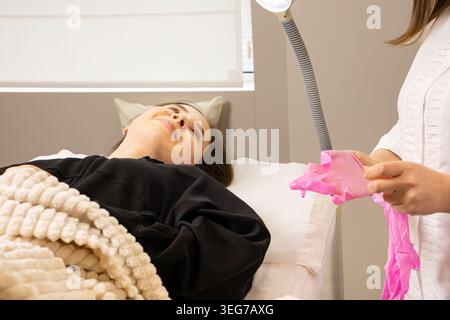 Une image d'une jeune femme très belle et attrayante montrant le processus d'injection des lèvres et de rajeunissement, dans un bureau organisé professionnellement Banque D'Images