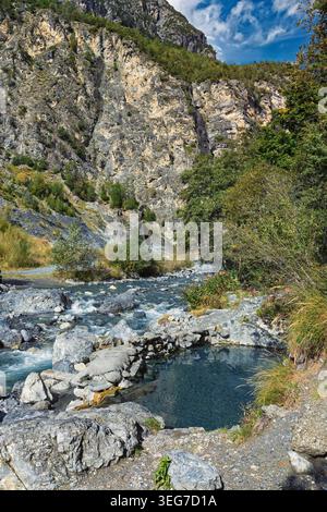 La pozza Bassa, Italie - 24.09.2024 : une scène montagneuse époustouflante avec une rivière qui coule avec des rapides blancs, entourée de rochers gris accidentés et luxuriants Banque D'Images