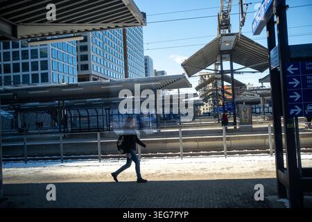 Un passager marche le long d'un quai de train entouré d'immeubles de bureaux modernes à la gare de Pasila à Helsinki, Uusimaa, Finlande, le 14 mars 2025. Platfo Banque D'Images