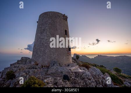 Historique Talaia d'Albercutx tour de guet sur un sommet rocheux dans le nord de Majorque pendant le coucher du soleil, avec une personne grimpant l'échelle et pittoresque côte Banque D'Images