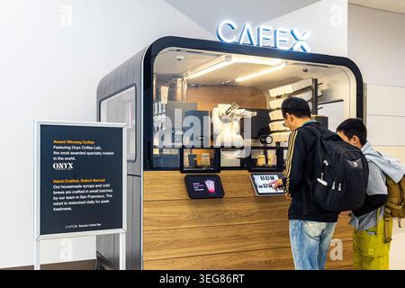 Café-bar robotique Cafe X à SFO San Francisco Airport, un homme qui commande du café à un barista robot servant du café Onyx, technologie futuriste de service alimentaire Banque D'Images