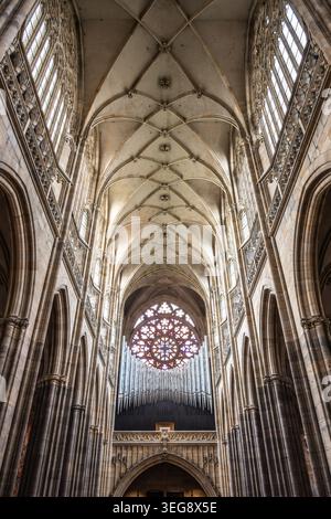 La vue intérieure de la cathédrale de la nouvelle Vitus montre de hauts plafonds, des arches et une rosace. Le design reflète le style gothique avec des détails complexes et un sens de l'histoire. Les visiteurs admirent la beauté. Banque D'Images