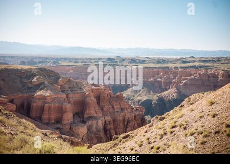 Une large vue panoramique sur Charyn Canyon avec des formations rocheuses spectaculaires, des falaises profondes et un paysage désertique en couches au Kazakhstan Banque D'Images
