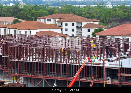 Développement de logements commerciaux aux Etats-Unis. Travaux de construction sur cadre monolithique. Grand chantier avec des ouvriers et des équipements dispersés. Réel Banque D'Images