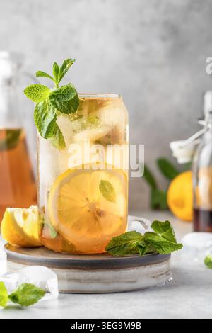 Thé au citron glacé en verre sur fond gris. Concept de boisson rafraîchissante froide d'été Banque D'Images