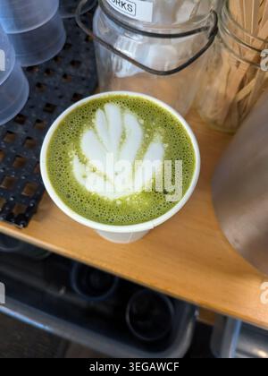 une tasse de latte matcha avec motif de feuilles dans la mousse Banque D'Images