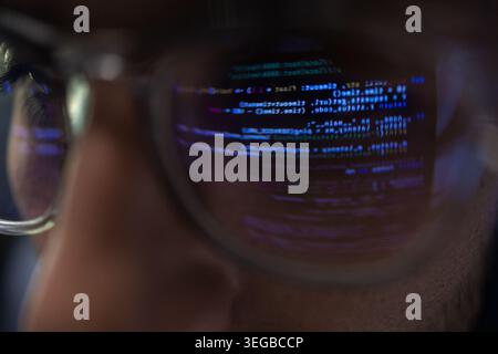 Gros plan des lunettes de programmateur avec réflexion de code sur l'objectif Banque D'Images