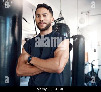 Homme, bras croisés et boxeur avec le sourire à la salle de gym en portrait avec fierté, confiance et bien-être. Personne, combattant et heureux pour les arts martiaux avec Banque D'Images