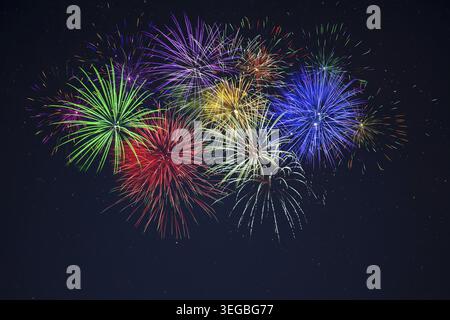 Scintillant violet vert rouge bleu jaune feux d'artifice de célébration au-dessus du ciel étoilé. Jour de l'indépendance, 4 juillet, les vacances du nouvel an saluent le fond Banque D'Images