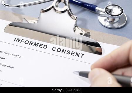 Remplir à la main un formulaire de consentement éclairé sur le bureau Banque D'Images