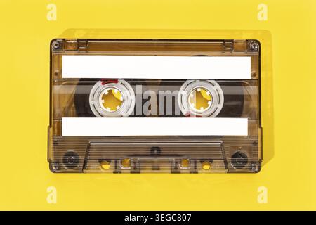 Ancienne cassette à ruban avec étiquettes vierges isolée sur fond jaune, maquette de modèle Banque D'Images