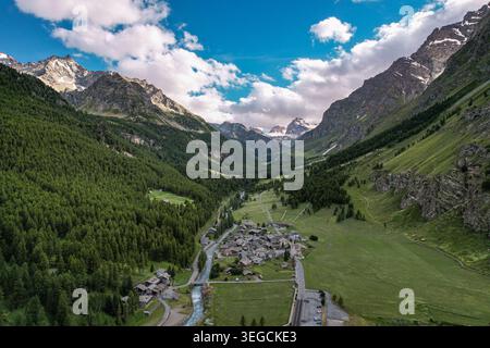 Vue aérienne du village de Rhemes-notre-Dame niché dans une vallée de montagne profonde entourée de forêts de pins et de hauts sommets Rhemes-notre-Dame, Valle d Banque D'Images
